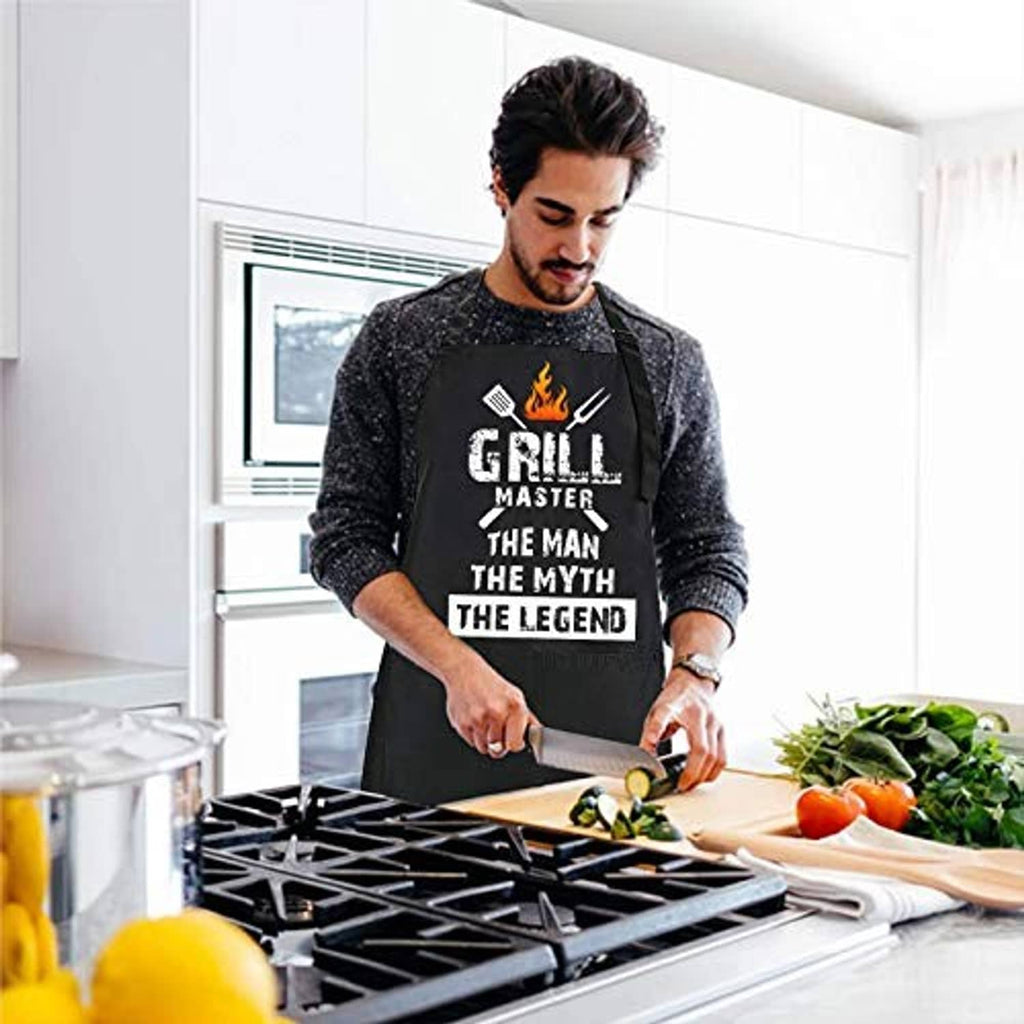 Black BBQ apron worn by cook, Grill Master flame logo and slogan print