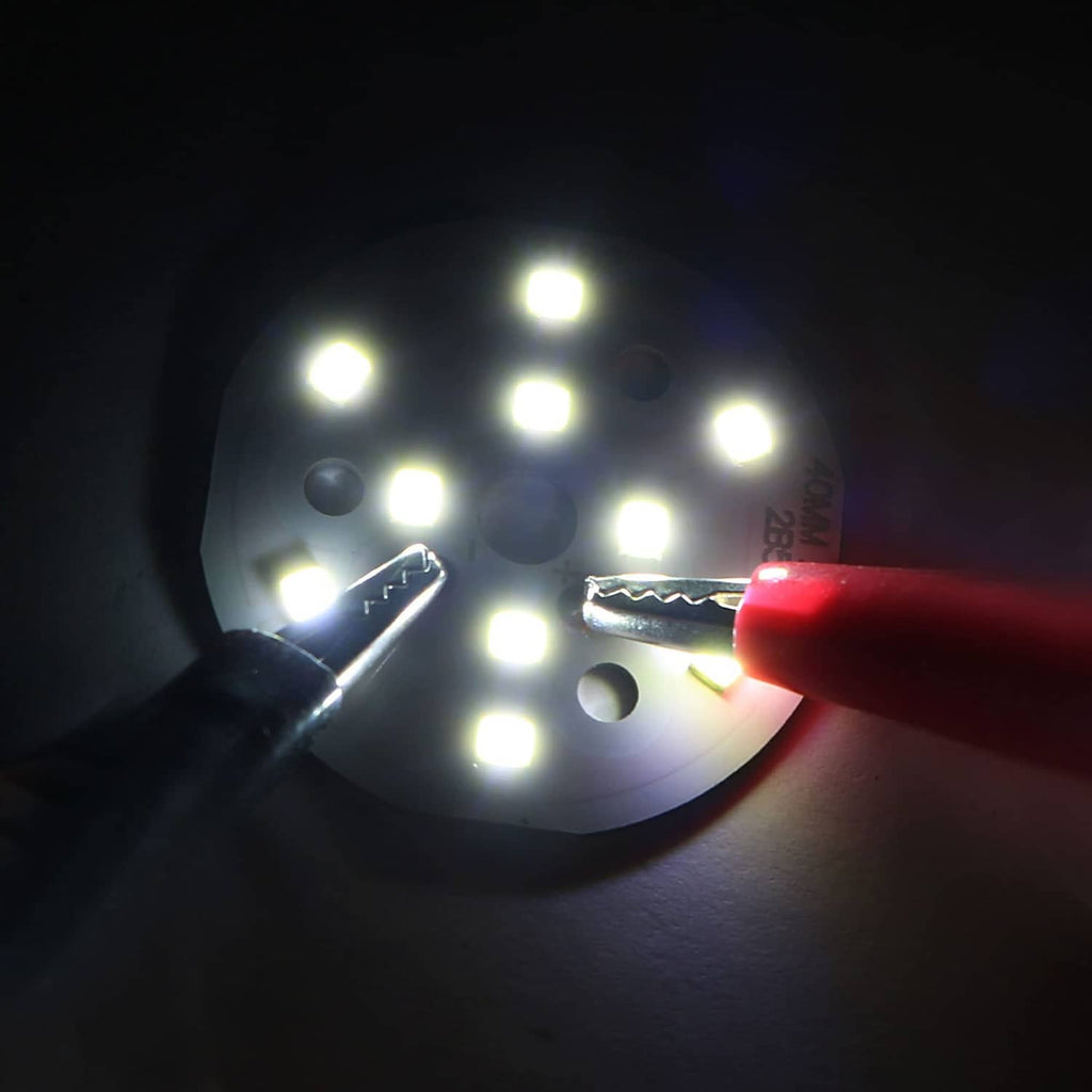 Round LED chip board glowing bright white with two electrical leads