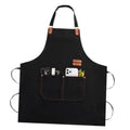 Black chef apron with front organizer pockets and brown leather handle accents