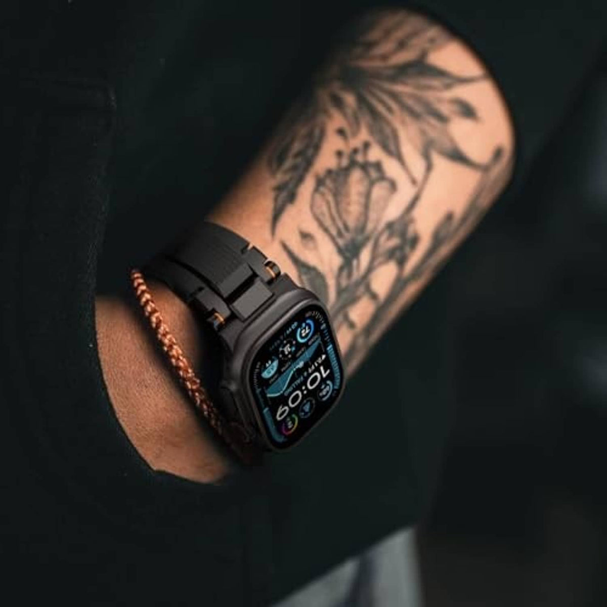 Matte black rugged watch band on wrist with smartwatch display and orange accents
