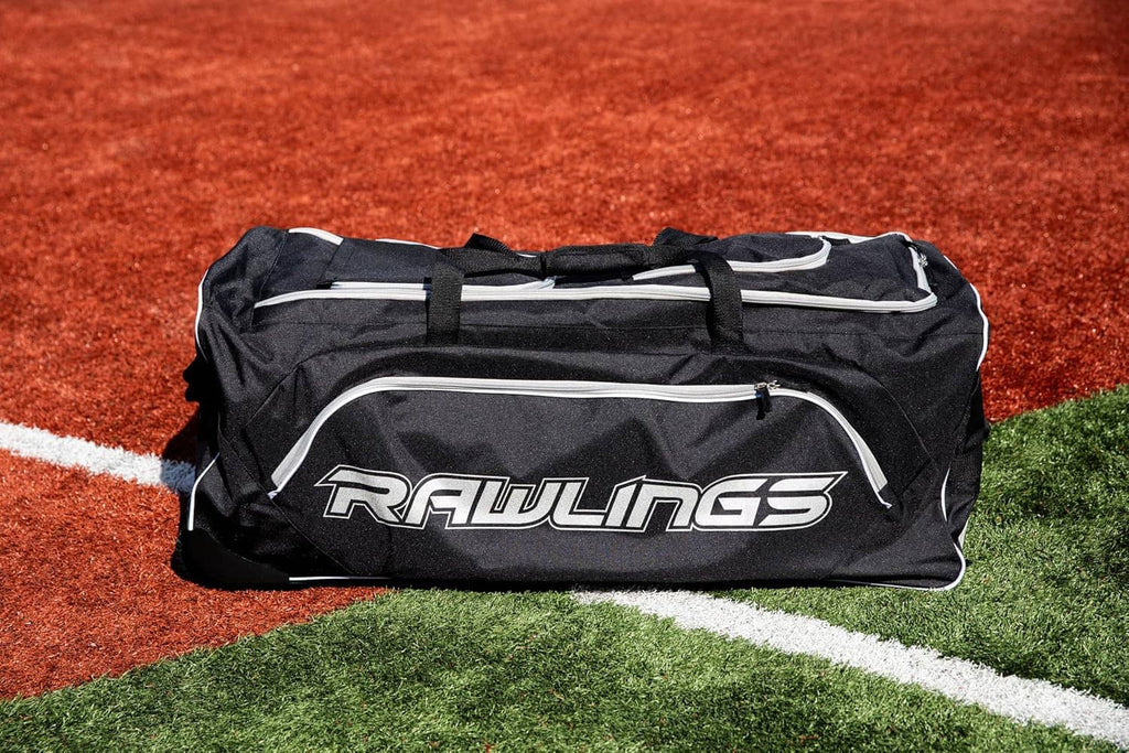 Black Rawlings wheeled catcher’s bag with white piping and two zipper compartments