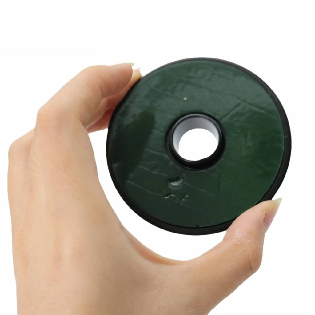 Green hood pin washer disk with center hole held in hand