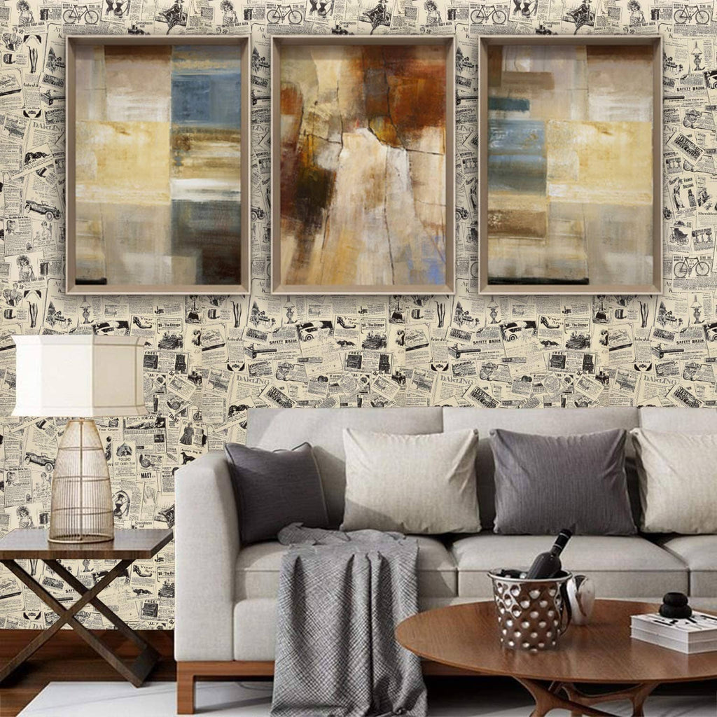 Newspaper-pattern wall covering with three framed panels above a gray sofa