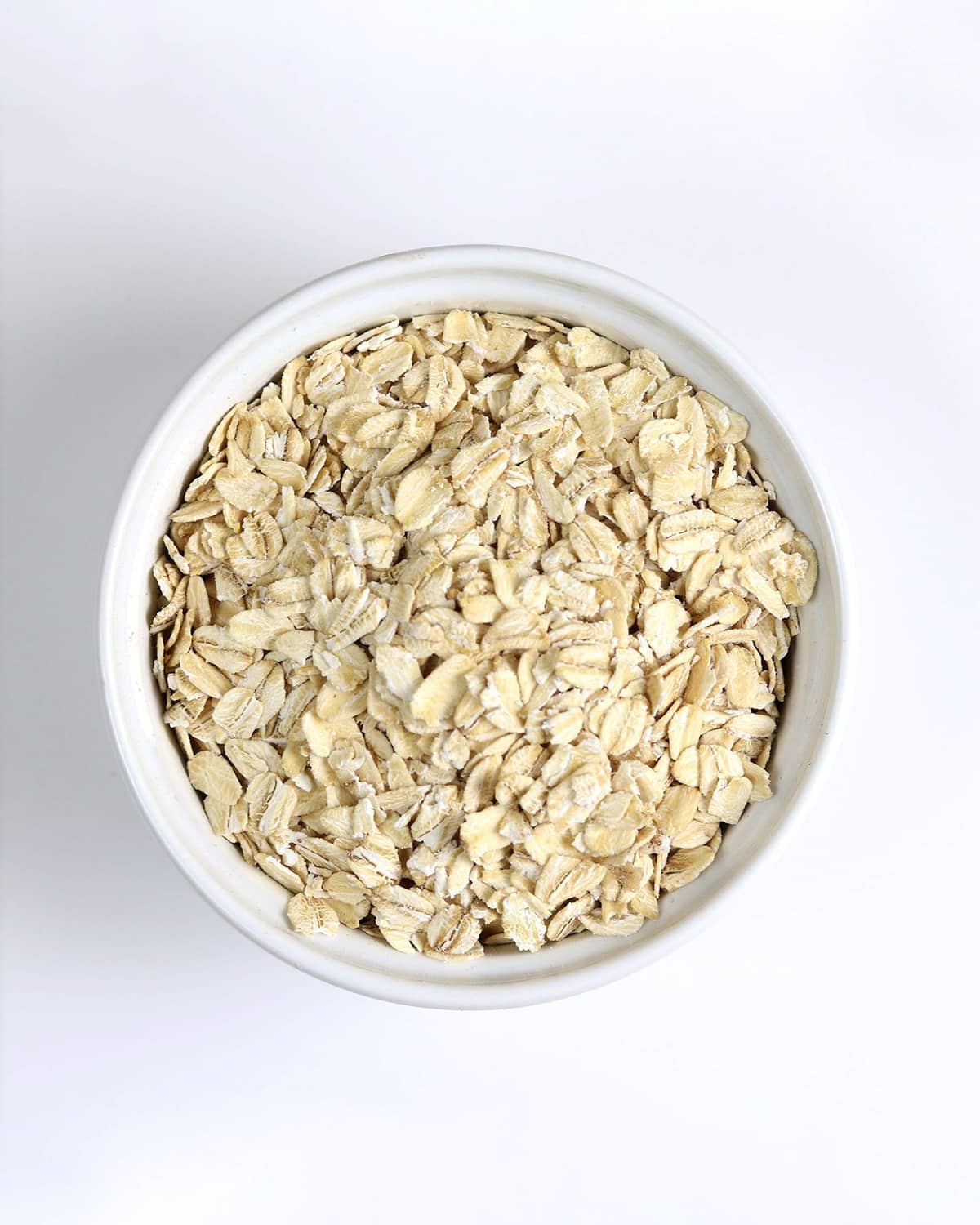 Bowl of rolled oats flakes, light tan dry oats