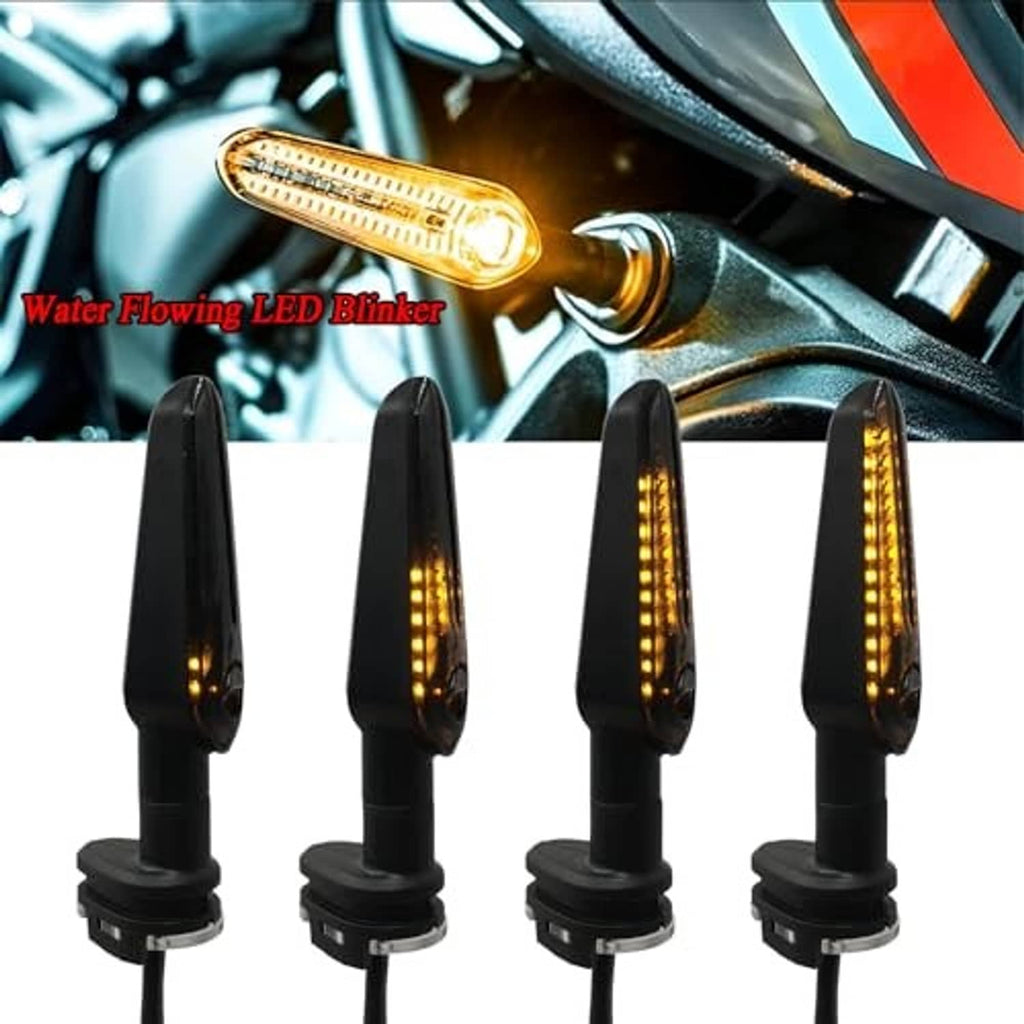 Four black motorcycle LED arrow turn signals glowing amber