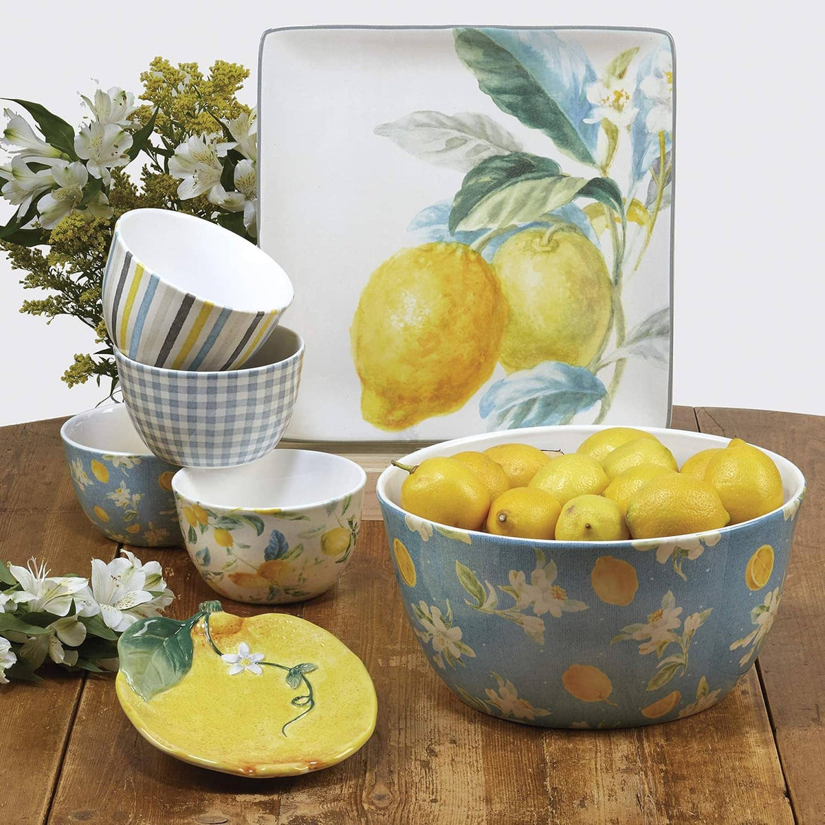 Lemon-pattern ceramic bowls and serving dish in blue and yellow, with platter and small plates