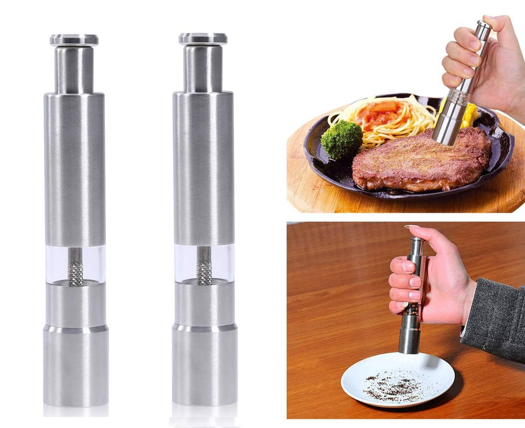 Stainless steel salt and pepper grinders, shown with push button and seasoning on food