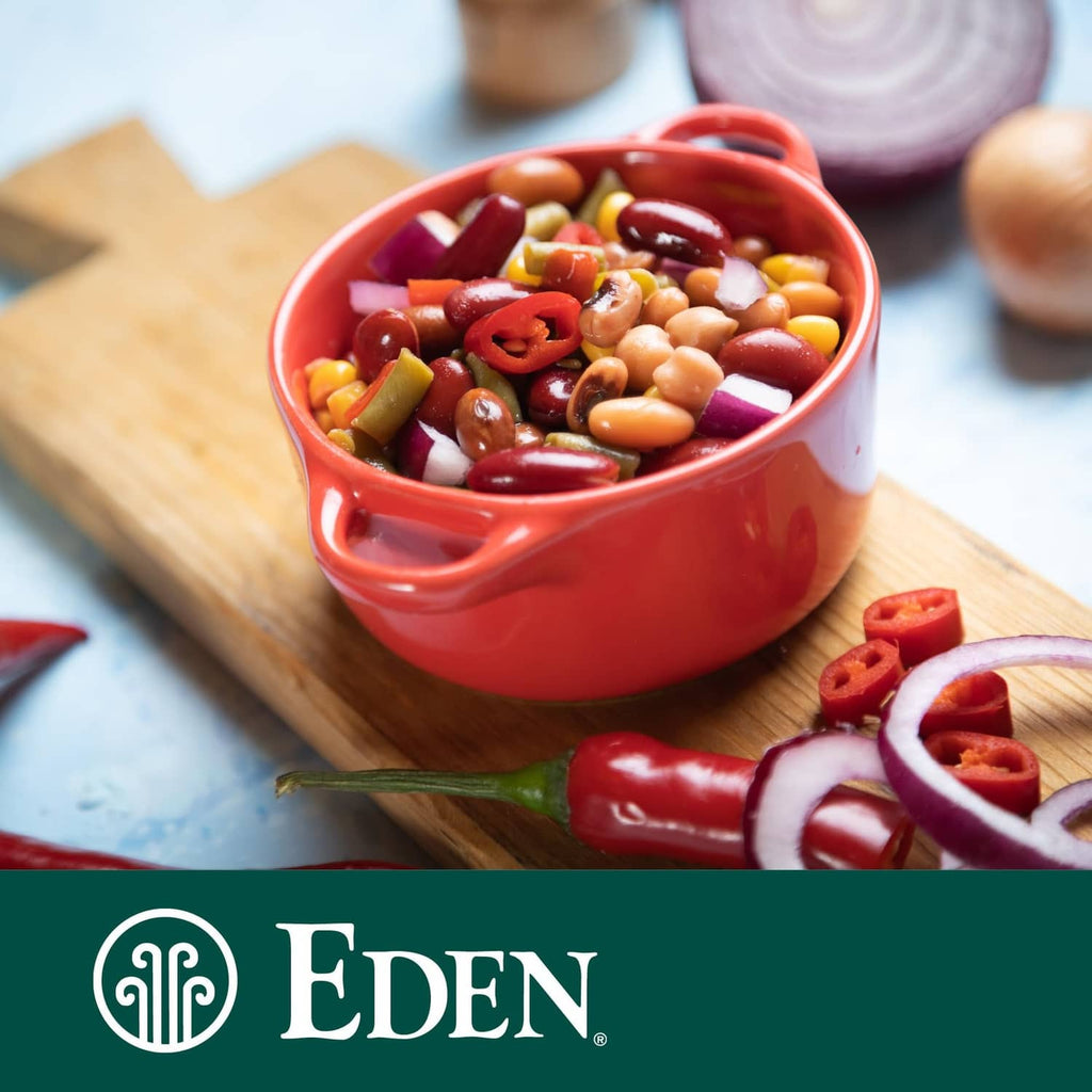 Bowl of beans with red peppers and onion on a board, Eden brand logo