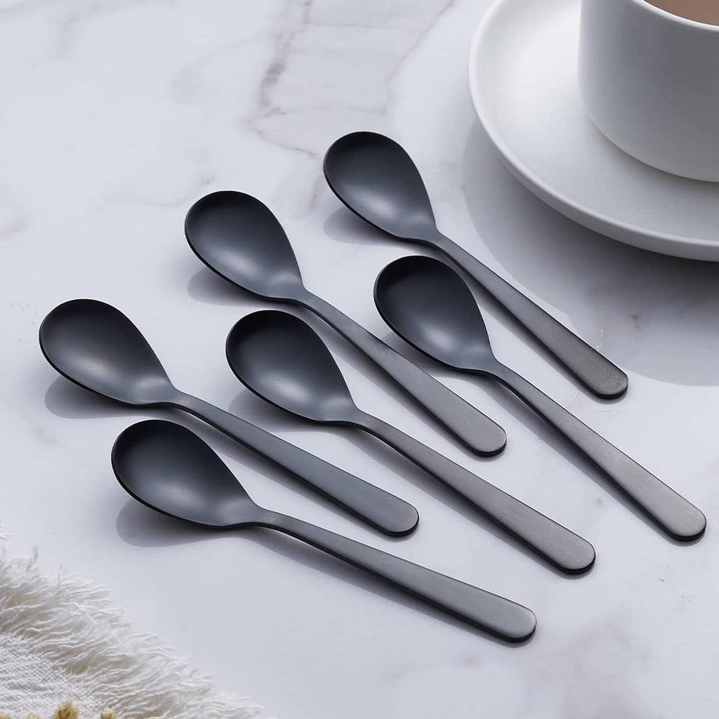 Matte black demitasse espresso spoons, rounded bowls on display with cup