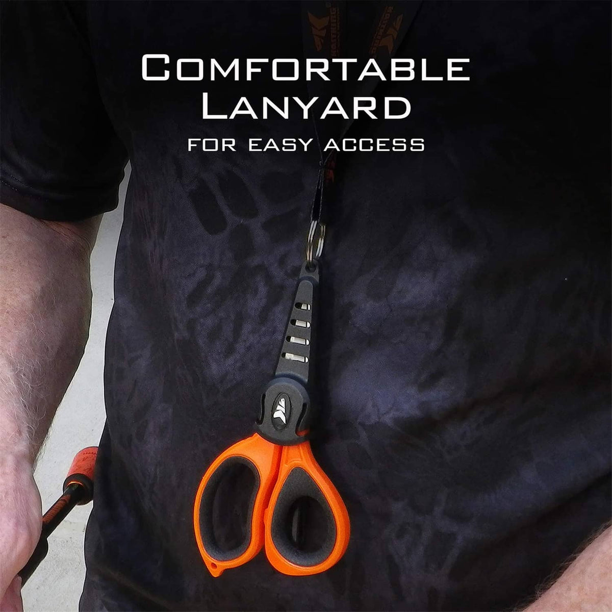 Orange-and-black fishing line scissors with black lanyard hanging from a sheath