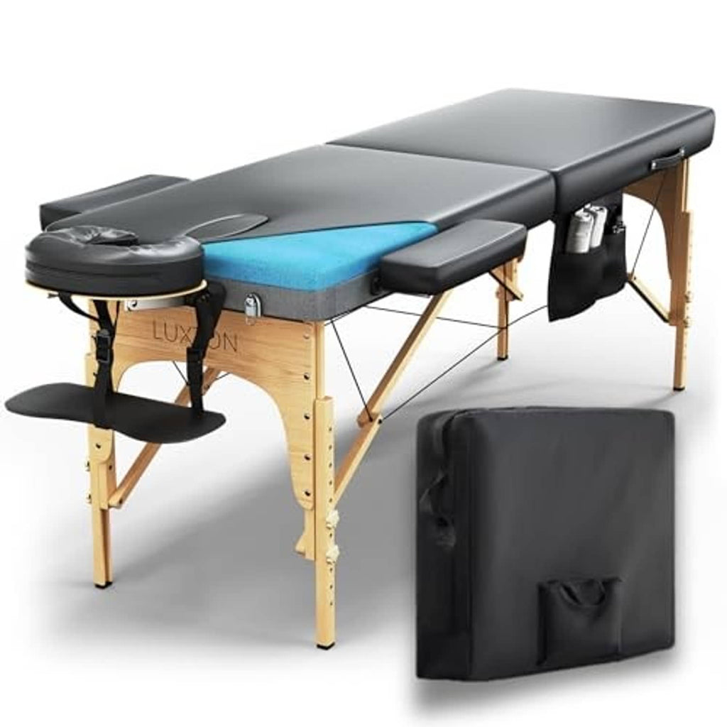 Massage table with blue memory-foam pad, black armrests, wooden legs, black carry case