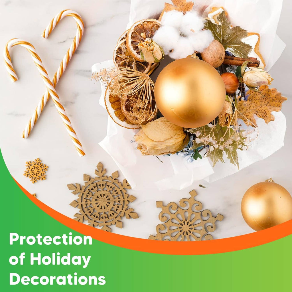 White packing paper wrapping holiday decorations with ornaments and ribbon