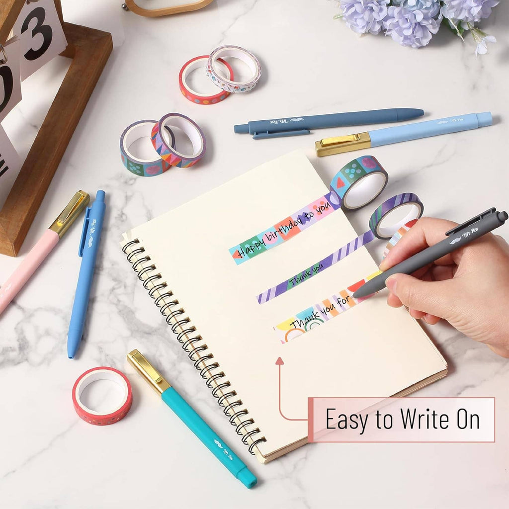 Colorful washi tape strips and rolls on notebook while writing and decorating