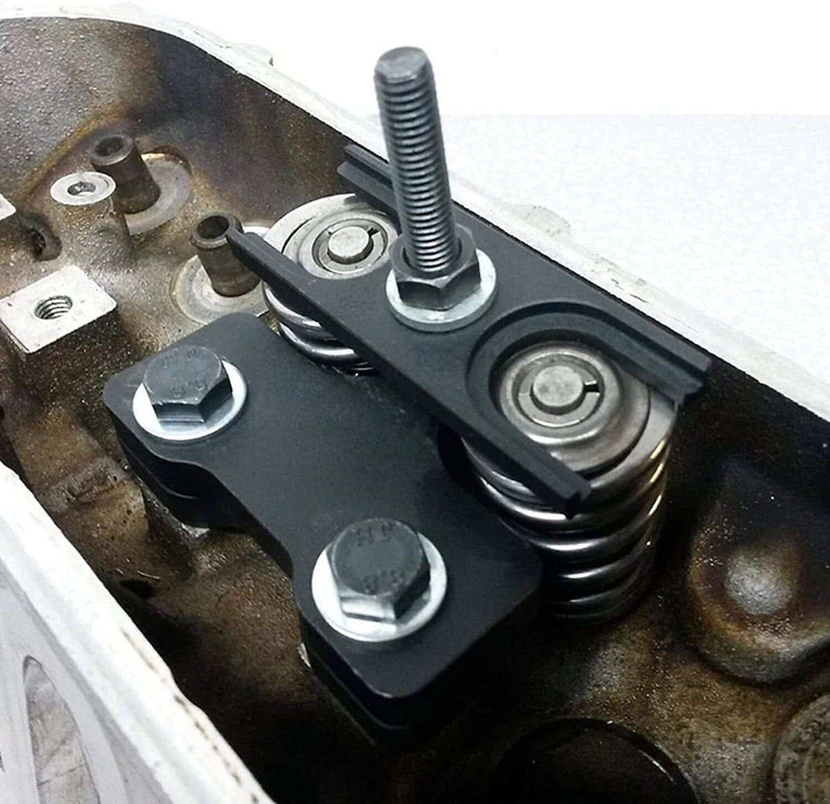 Valve spring compressor installed on engine head with threaded center bolt