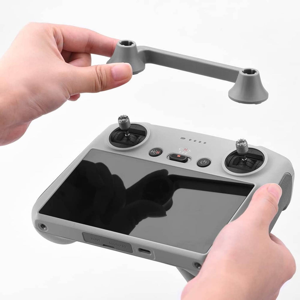 Grey joystick protector fixator being attached to a remote controller