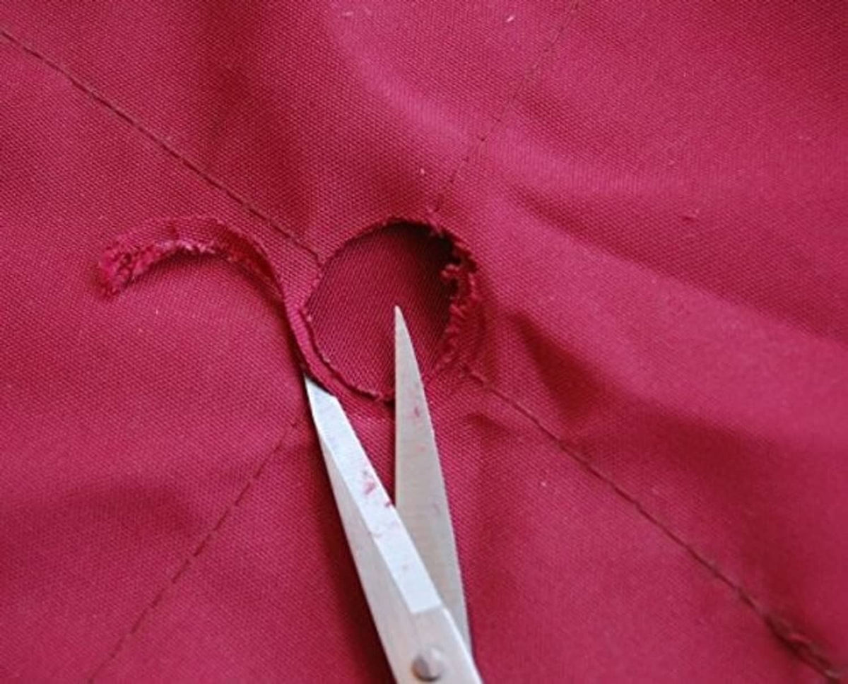 Close-up of umbrella canopy fabric seam with white trim on red material