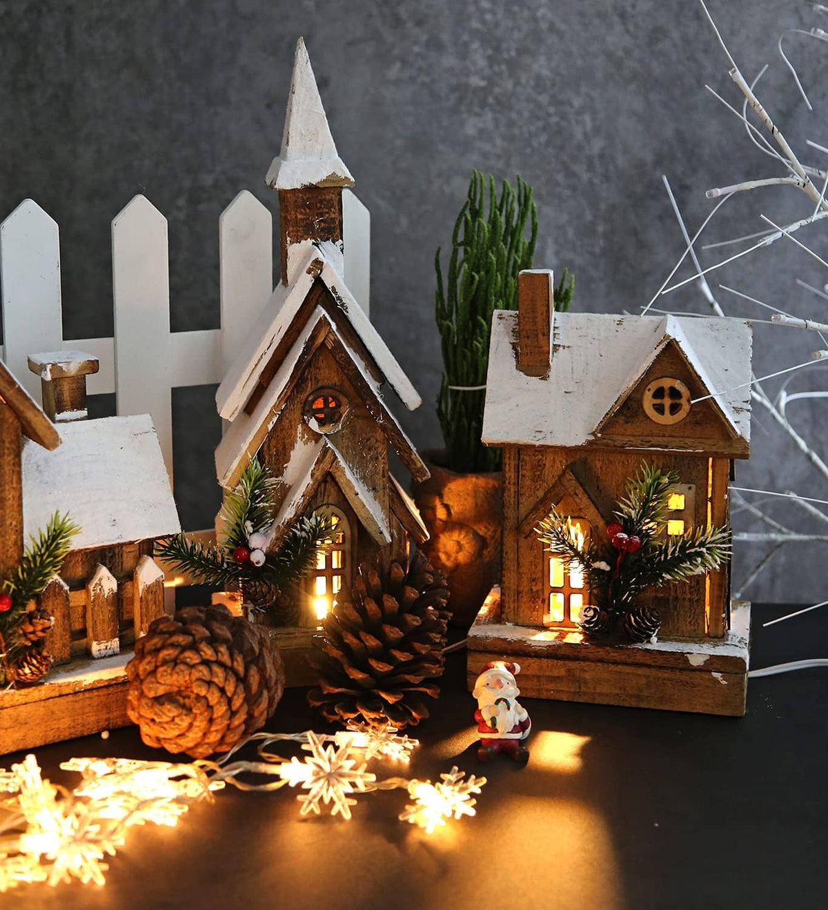 Mini lit Christmas village house decorations with warm LED lights, pinecones, and snow accents