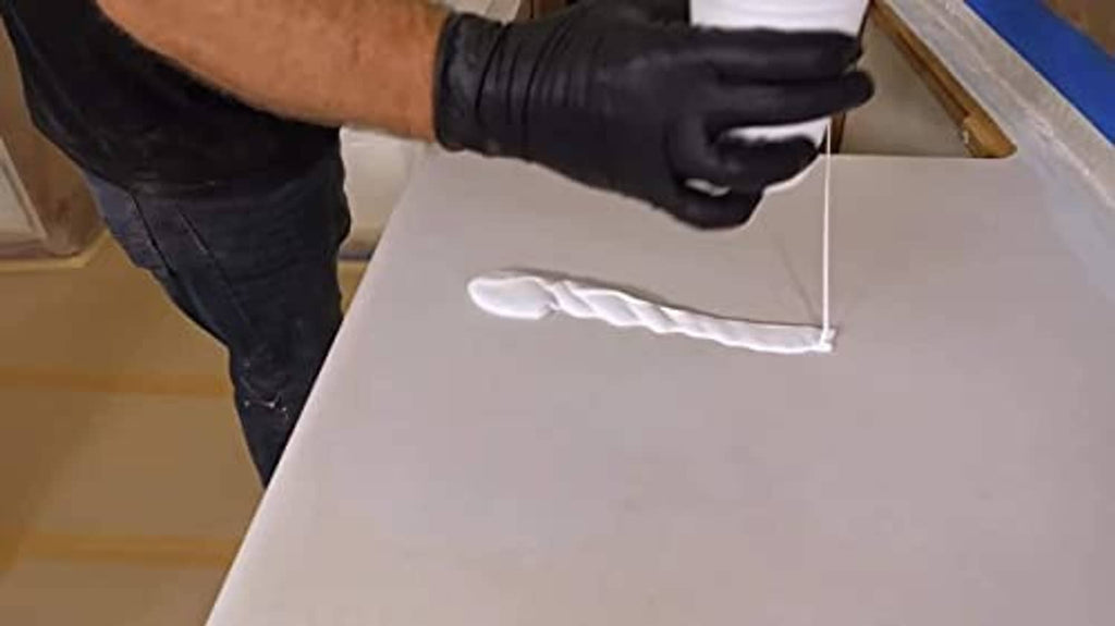 Epoxy undercoat being spread on a countertop panel with a roller tool