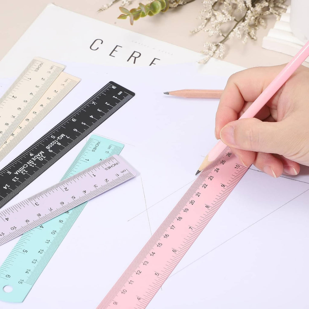 Pink metal ruler held in hand, with metric and inch scale markings