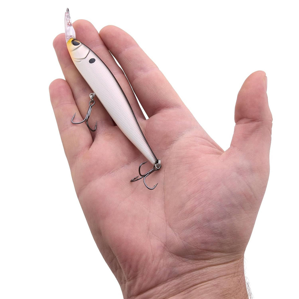 Fishing lure held in hand: white shad body with treble hooks