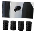 Four black textured tire valve stem caps with ribbed grip