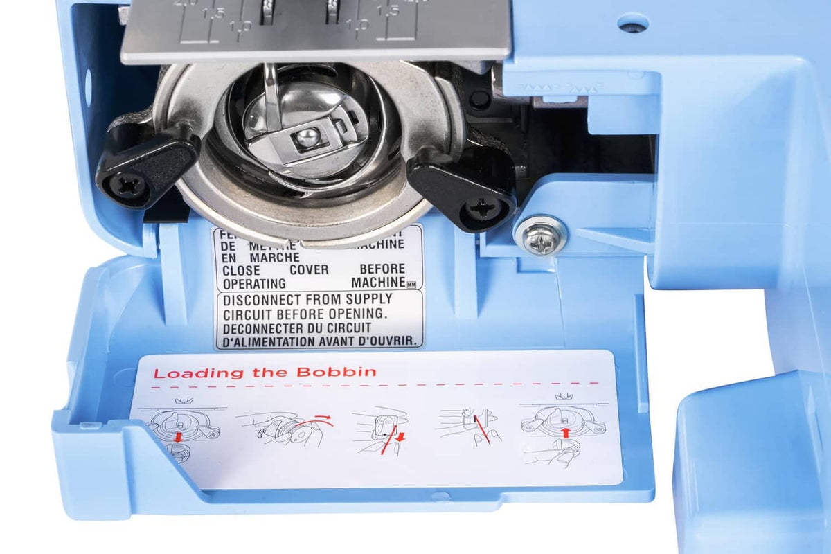 Janome sewing machine bobbin area open, showing loading guide inside
