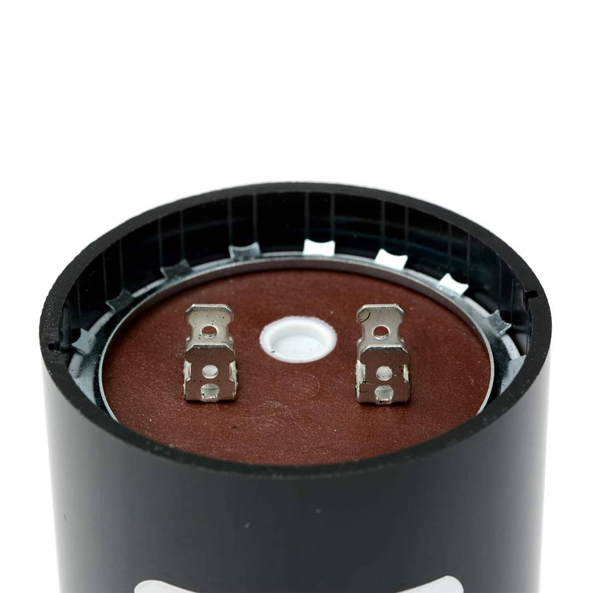 Close-up view of black cylindrical start capacitor terminals and center insulator