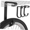 Black overhead bike hook with curved prongs holding a bicycle tire