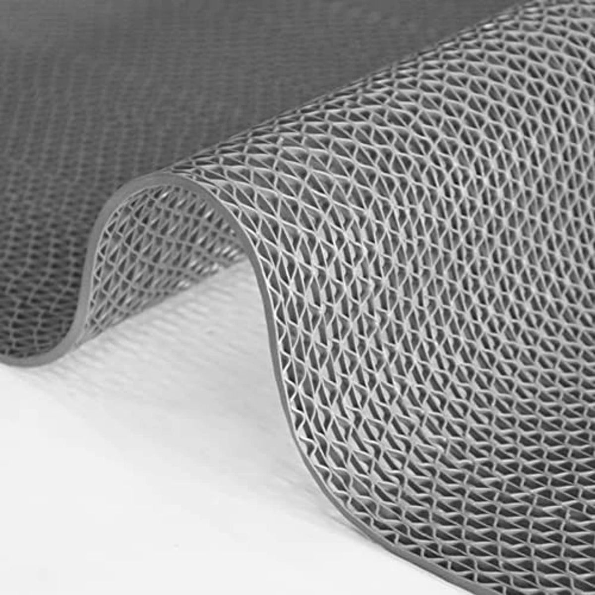 Gray drainage pool floor mat corner with raised mesh texture and curled edge