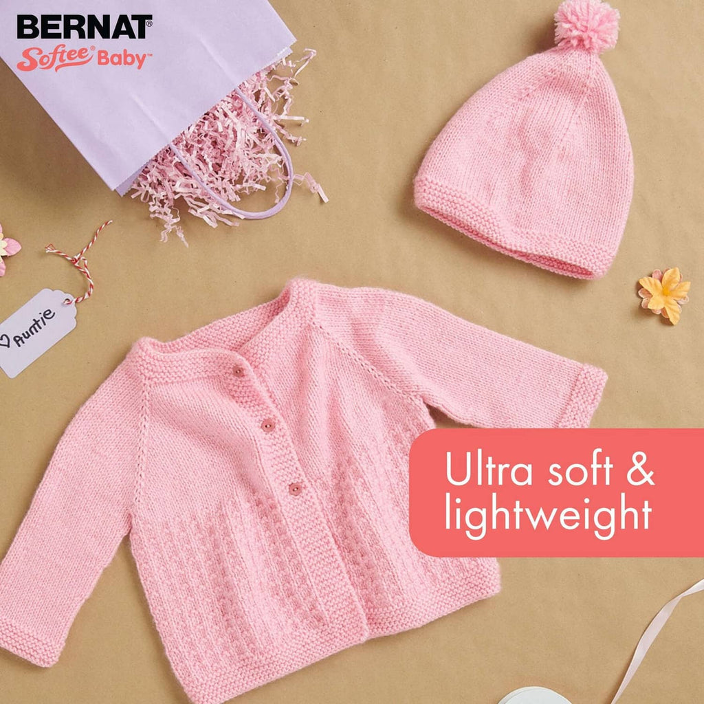 Pink baby cable-knit sweater and matching knitted hat with pom-pom