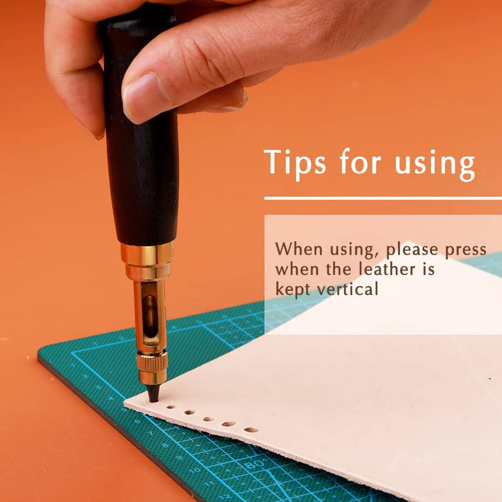 Automatic hole punch tool pressing into light leather on a green gridded mat