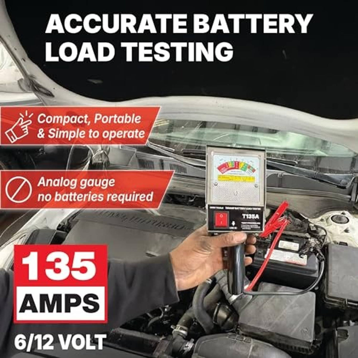Battery load tester with analog gauge unit and red clamp leads on a vehicle engine bay