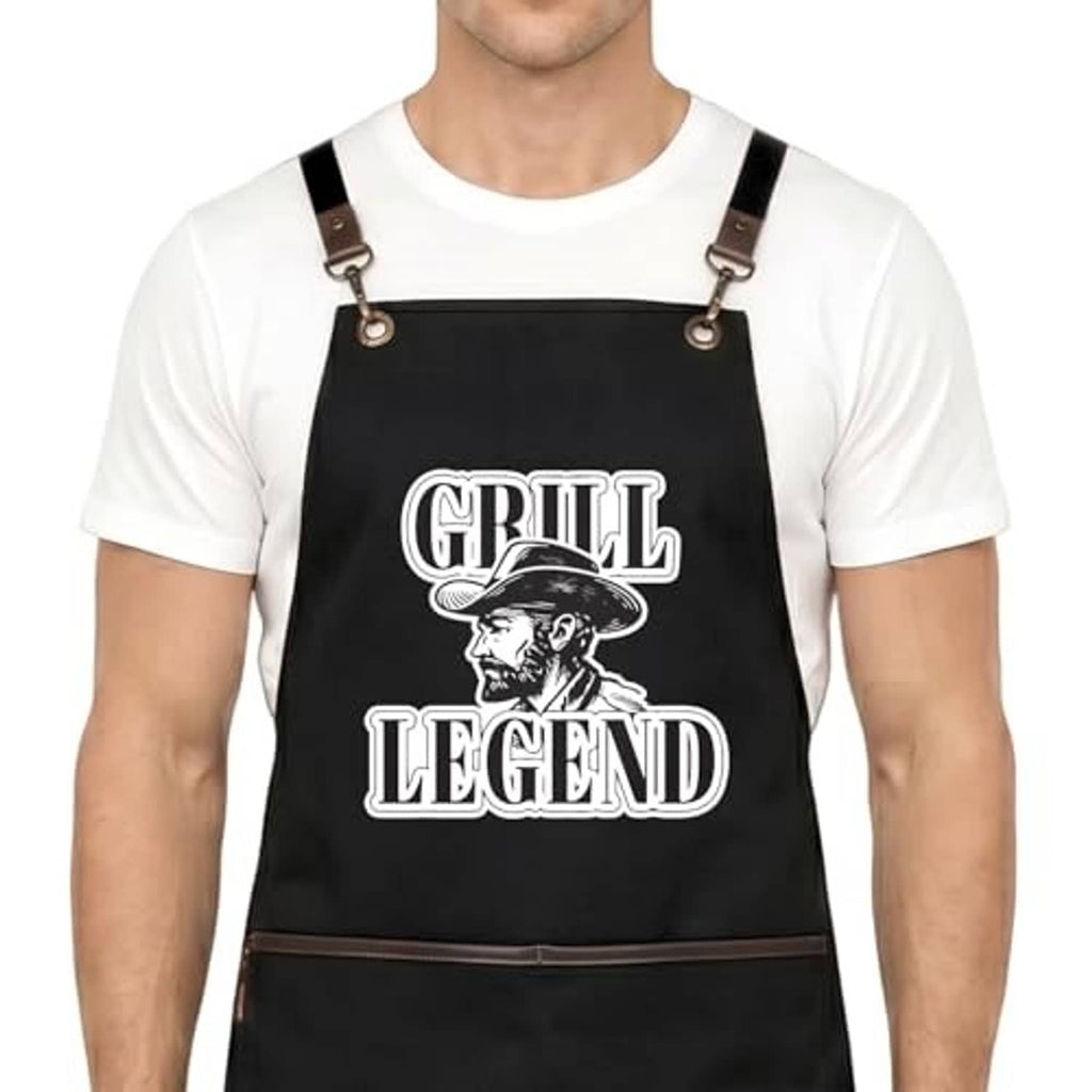 Black apron with Grill Legend print; adjustable cross-back straps and metal buckles.