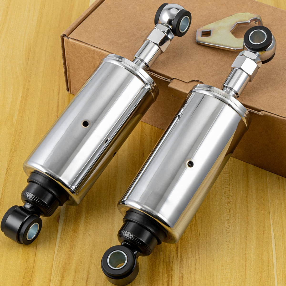Pair of chrome rear shocks with black end caps and curved mounting brackets