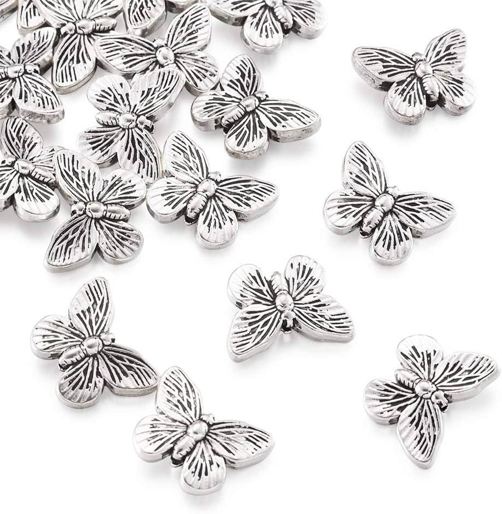 Antique silver butterfly spacer beads, close-up view with engraved petal-like lines