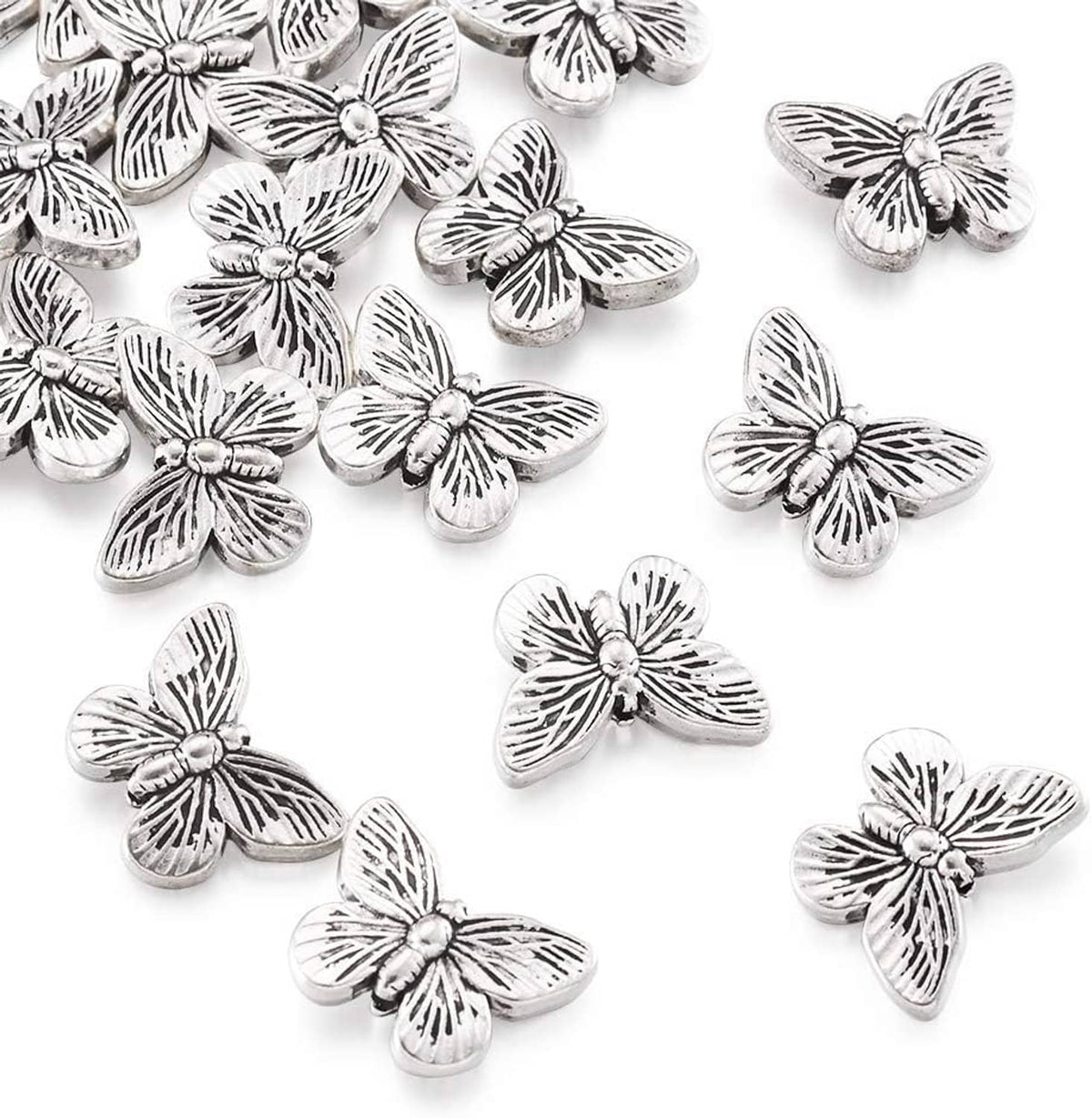 Antique silver butterfly spacer beads, close-up view with engraved petal-like lines