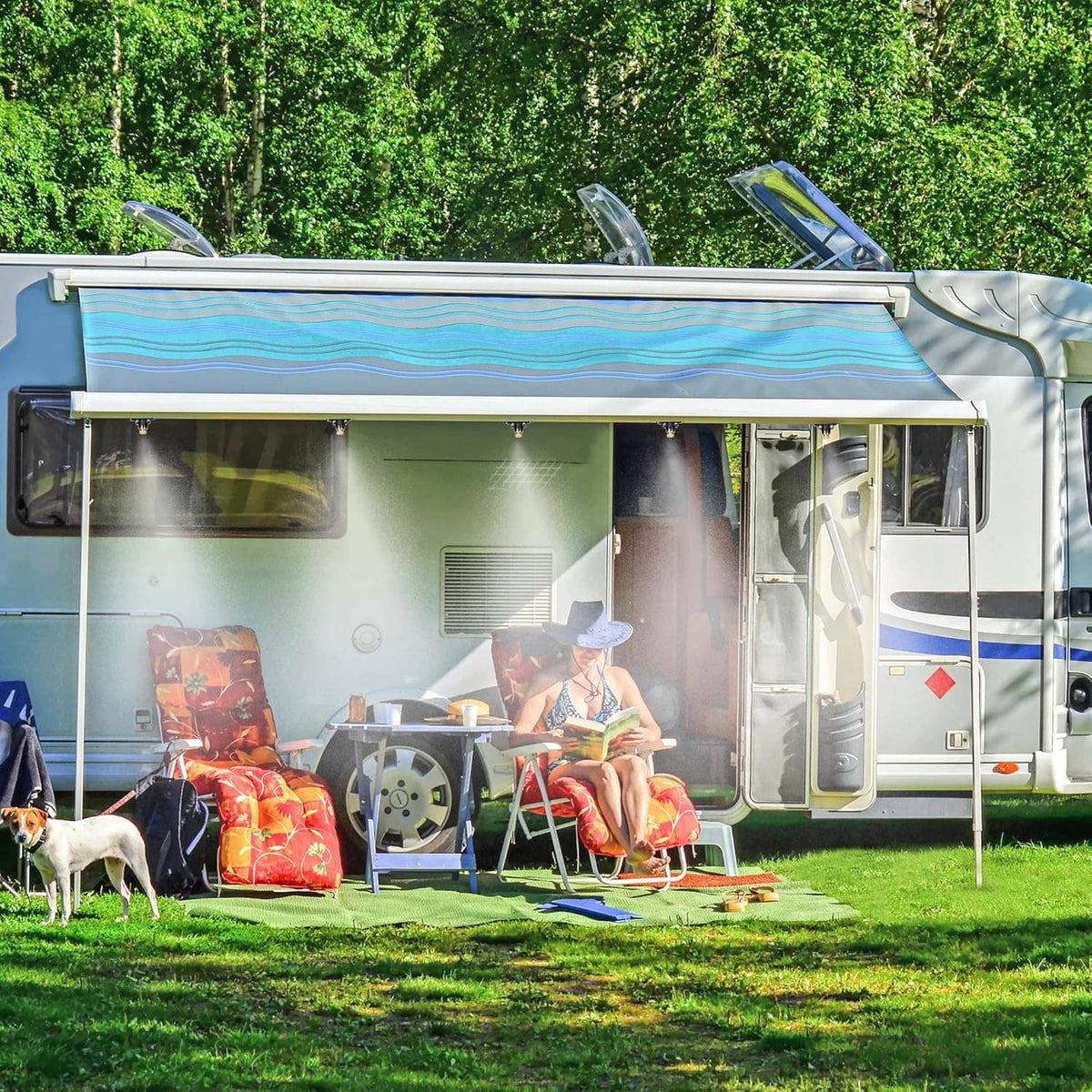Outdoor cooling misting spray near RV camper on grass