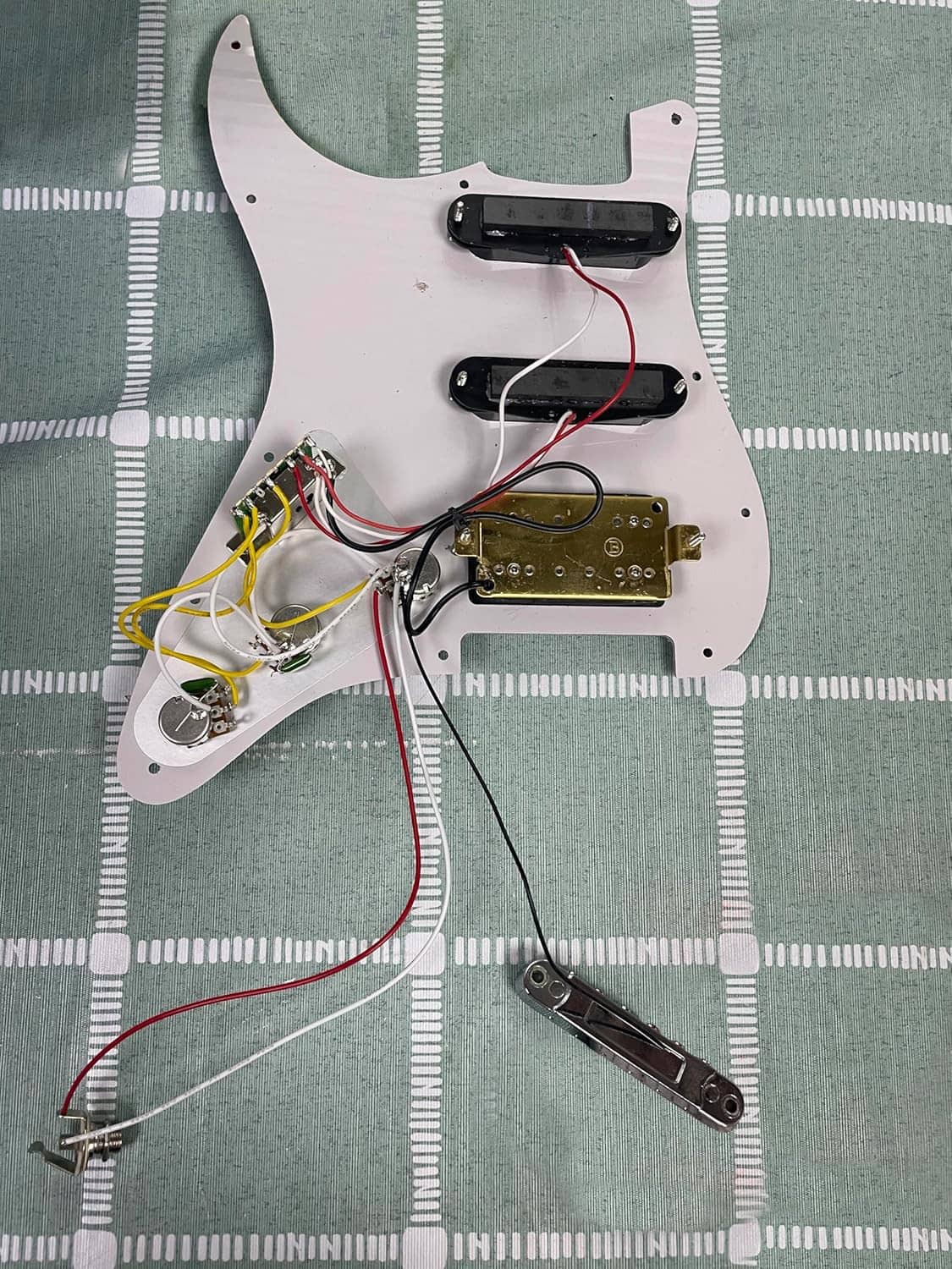 Black pickguard underside with wiring harness, pots, and pickup connection terminals
