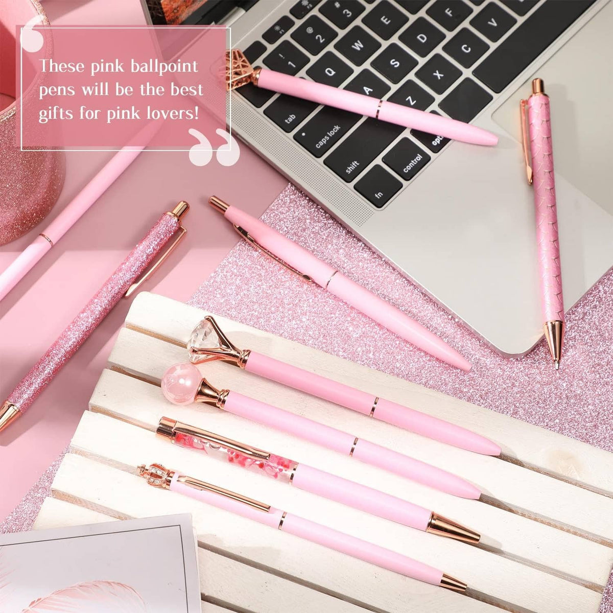 Assorted pink ballpoint pens with glitter finishes on desk, 9-piece set layout