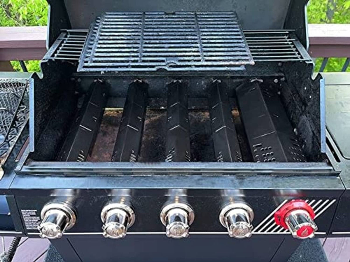 Installed grill heat plates inside a gas grill, showing burner area and knobs