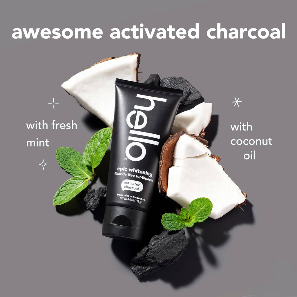 Activated charcoal toothpaste tube with mint leaves, charcoal pieces, and coconut