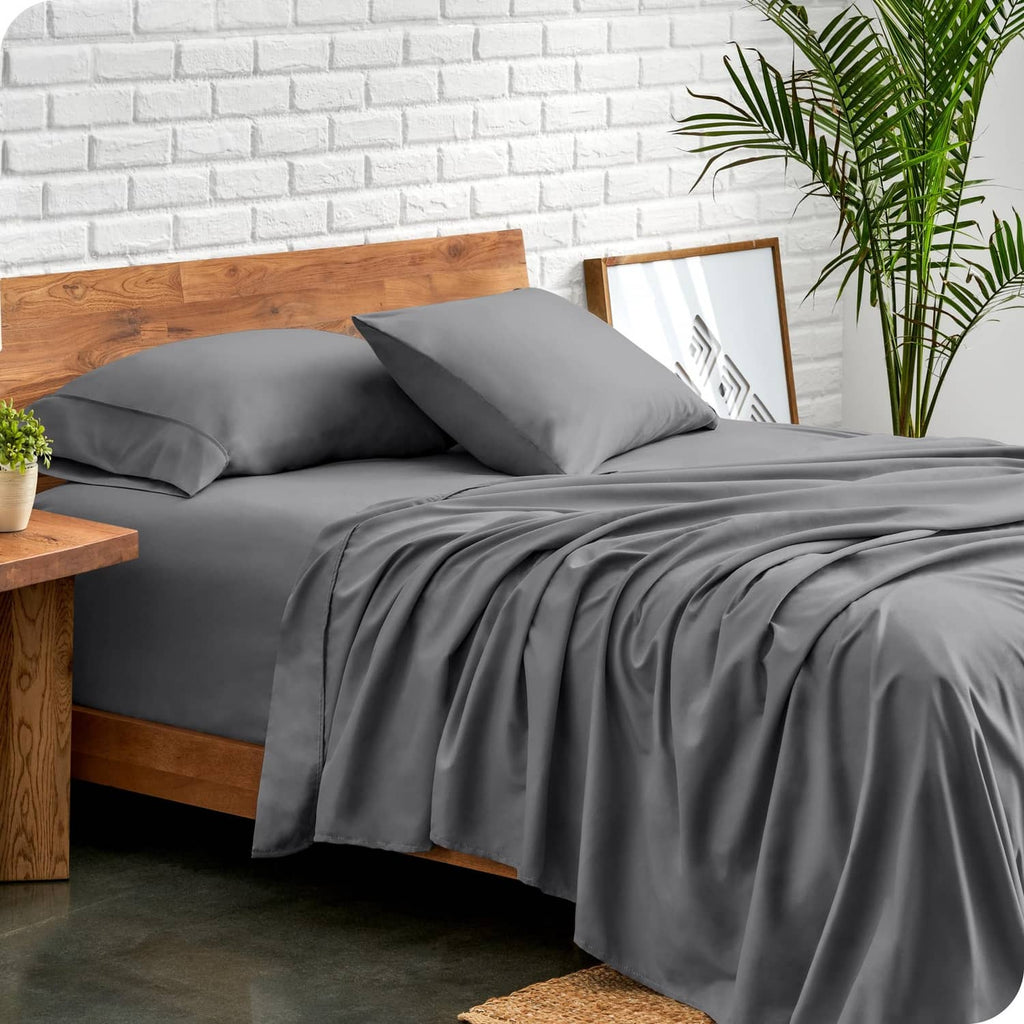 Grey fitted sheet and pillowcases on split queen bed with two matching pillows