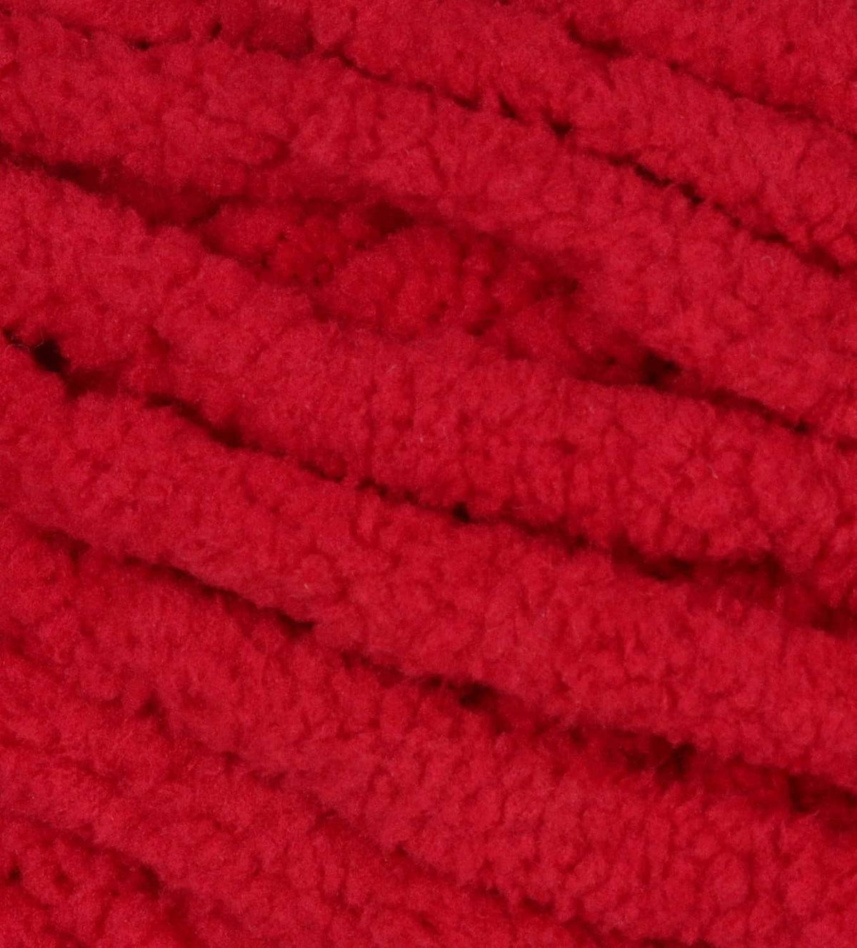 Close-up of cranberry red Bernat Blanket yarn knit texture with chunky loops