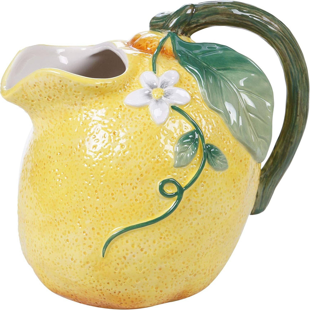 Ceramic lemon pitcher with yellow textured glaze, green leaf handle, and centered white flower