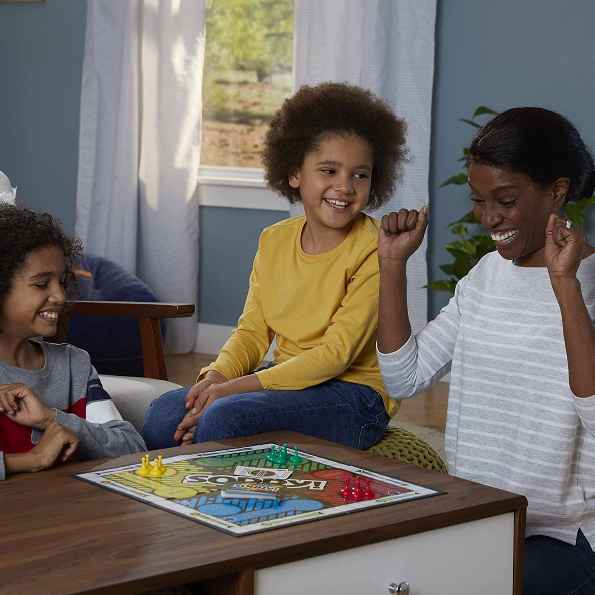 Children smiling while playing Sorry! board game on a living room table