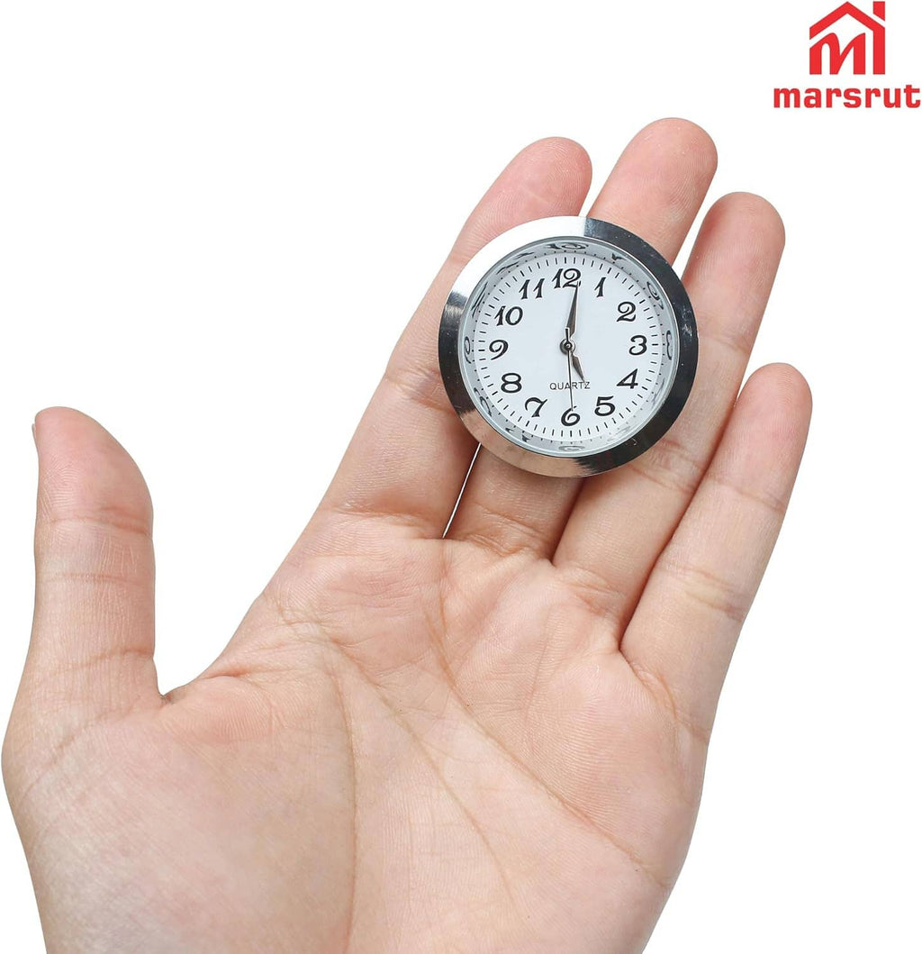 Small round clock face insert in hand: silver bezel, white dial, black Roman numerals