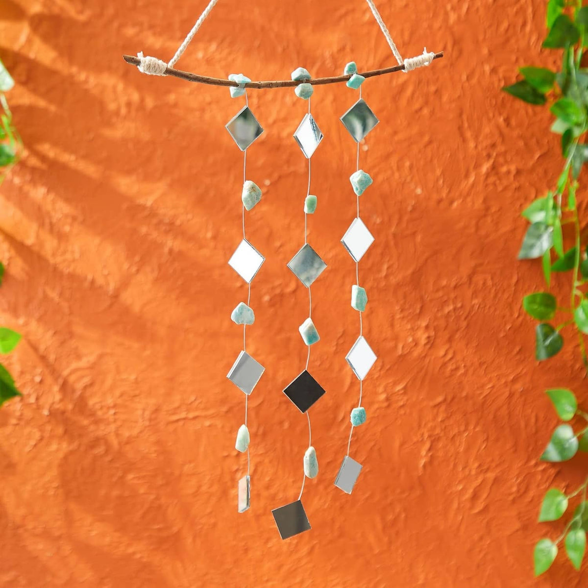 Small square mirror tiles strung with beads in a hanging craft garland