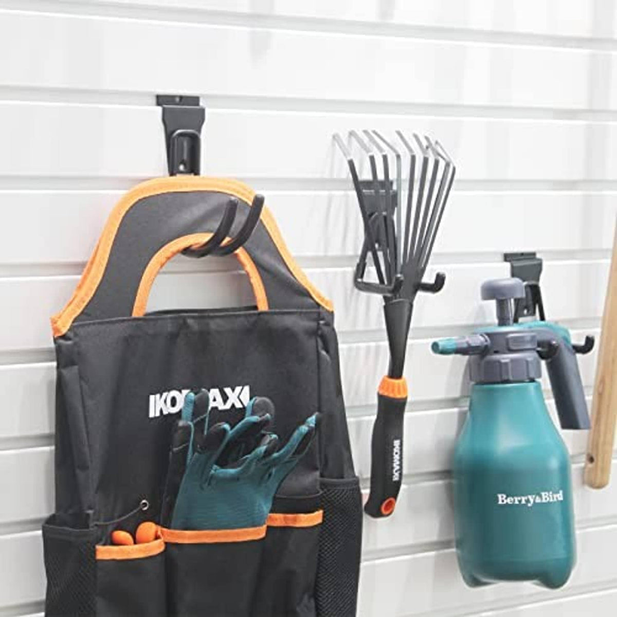 Black slatwall hooks mounted on wall, holding tools and items