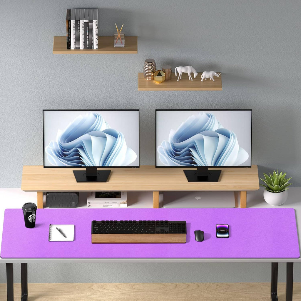 Violet desk pad protector under keyboard on a desk with dual monitors