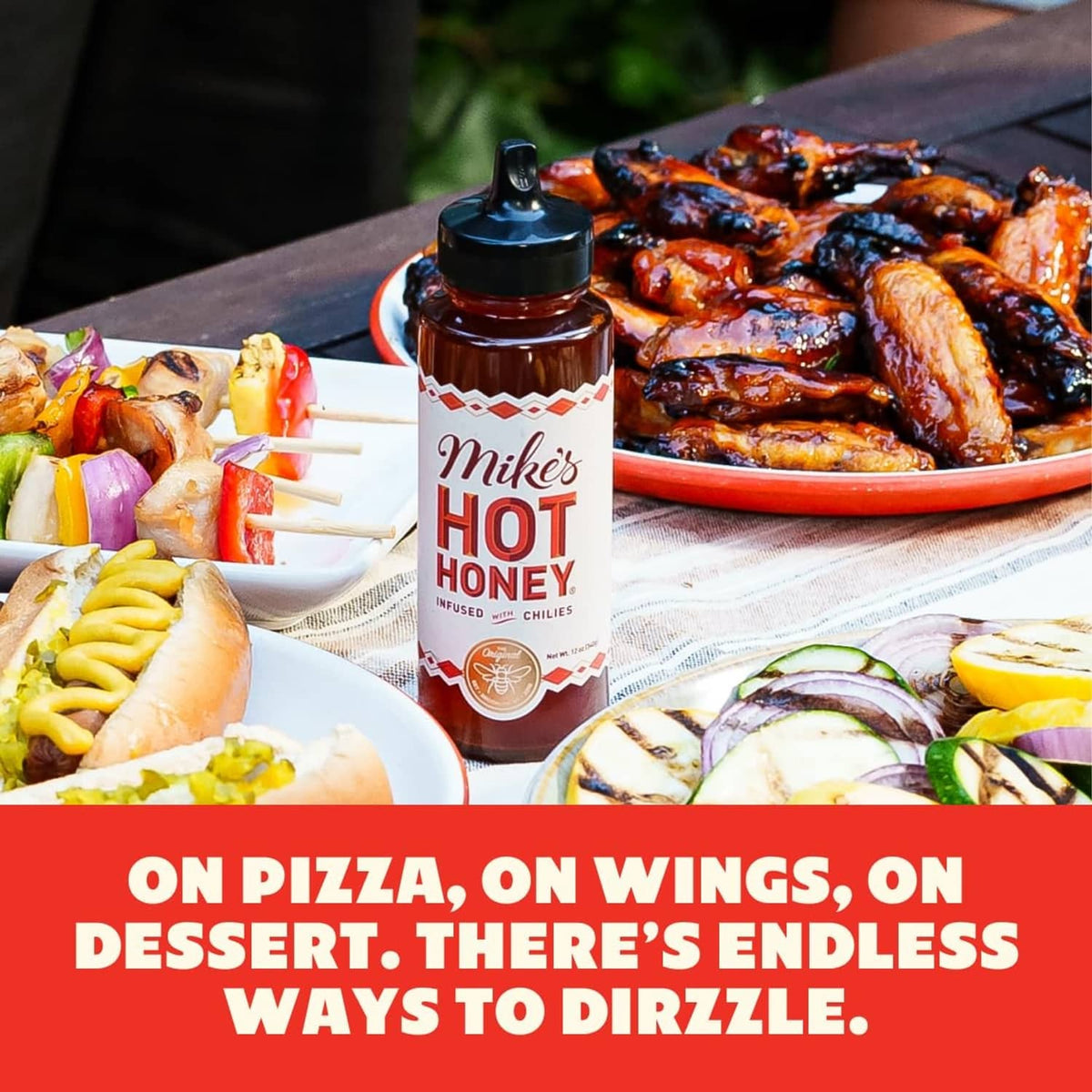 Extra hot honey squeeze bottle on a table with plated food